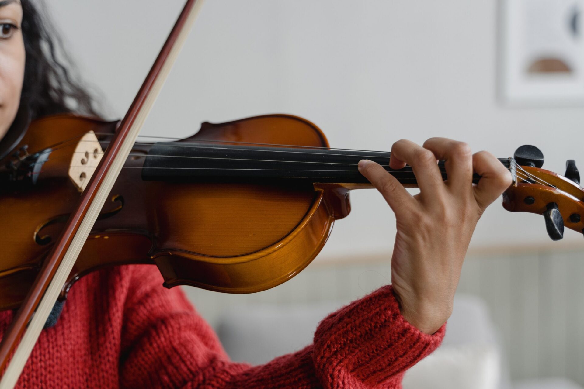zoom sur une enseignante qui joue du violon à domicile